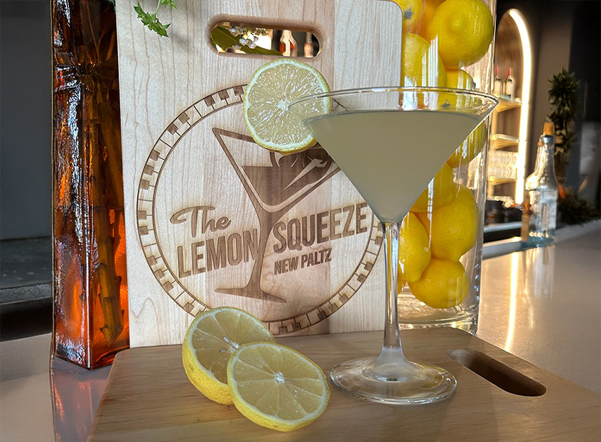 a glass of liquid with a drink on a cutting board