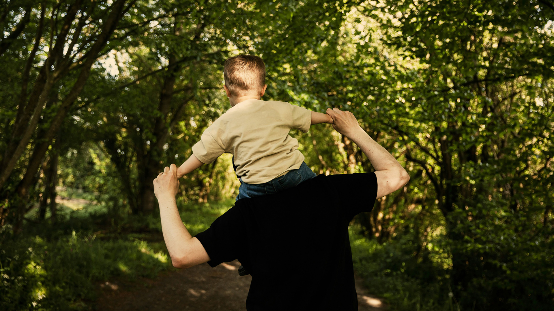 a man carrying a child on his shoulders