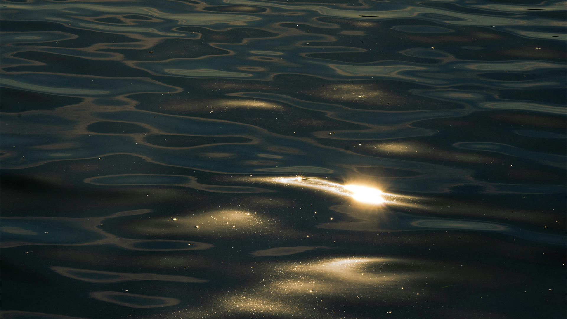 a sun shining on the water