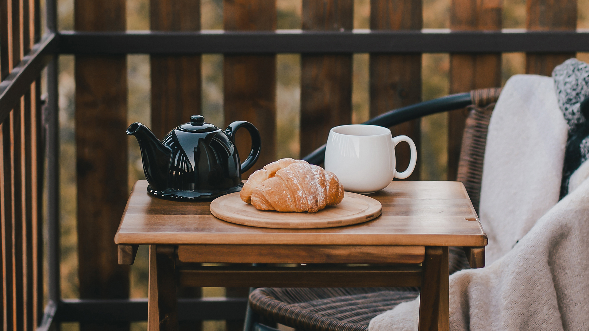 a croissant and a teapot on a table