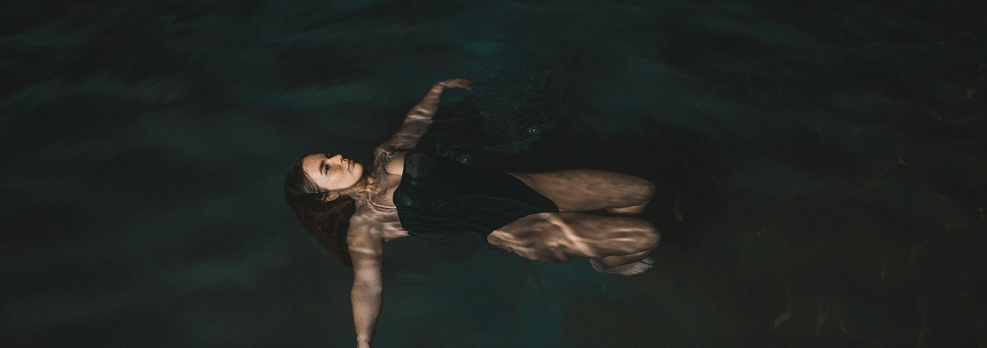 a woman in a black swimsuit floating in water