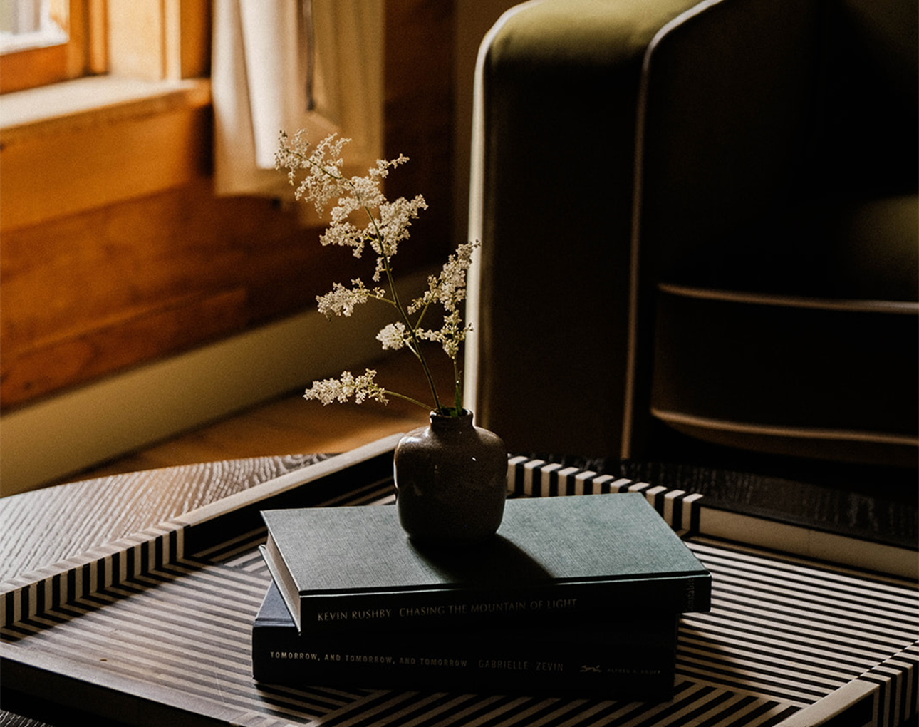 a vase with flowers on top of books