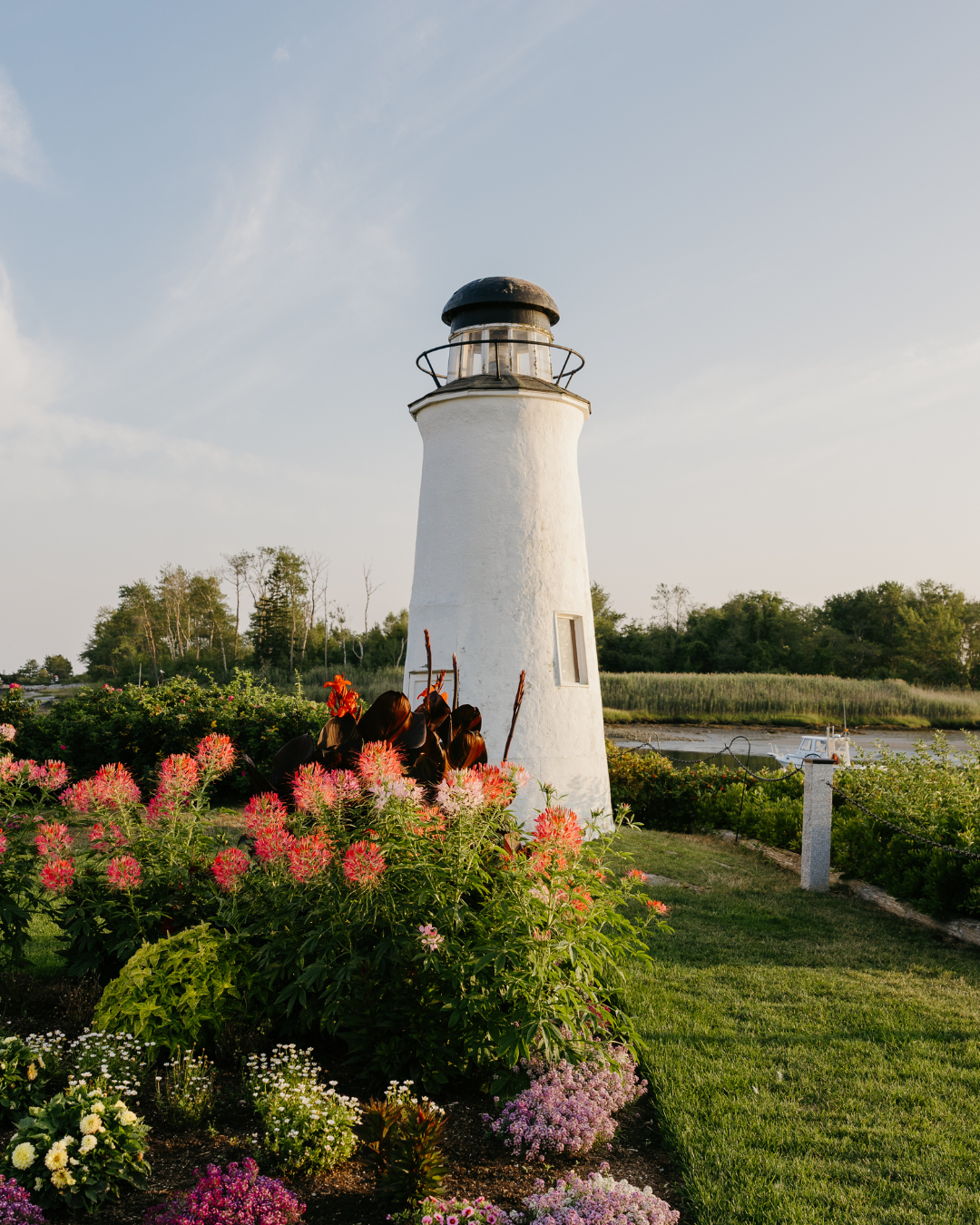 a lighthouse with flowers and grass