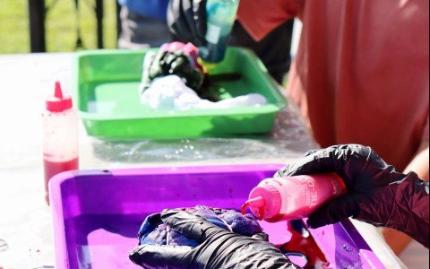 a person with gloves painting a purple object