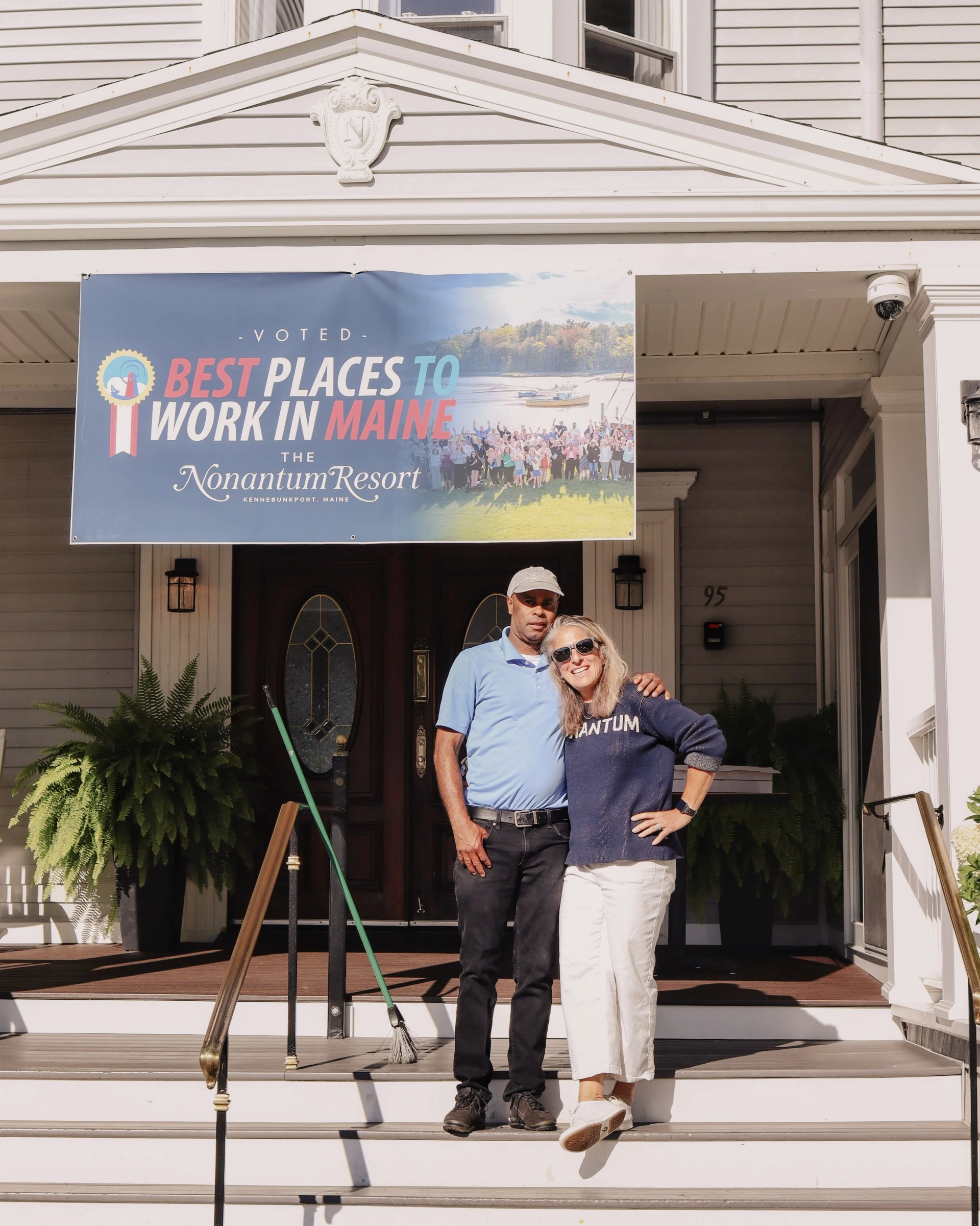 a man and woman standing on a porch of a house