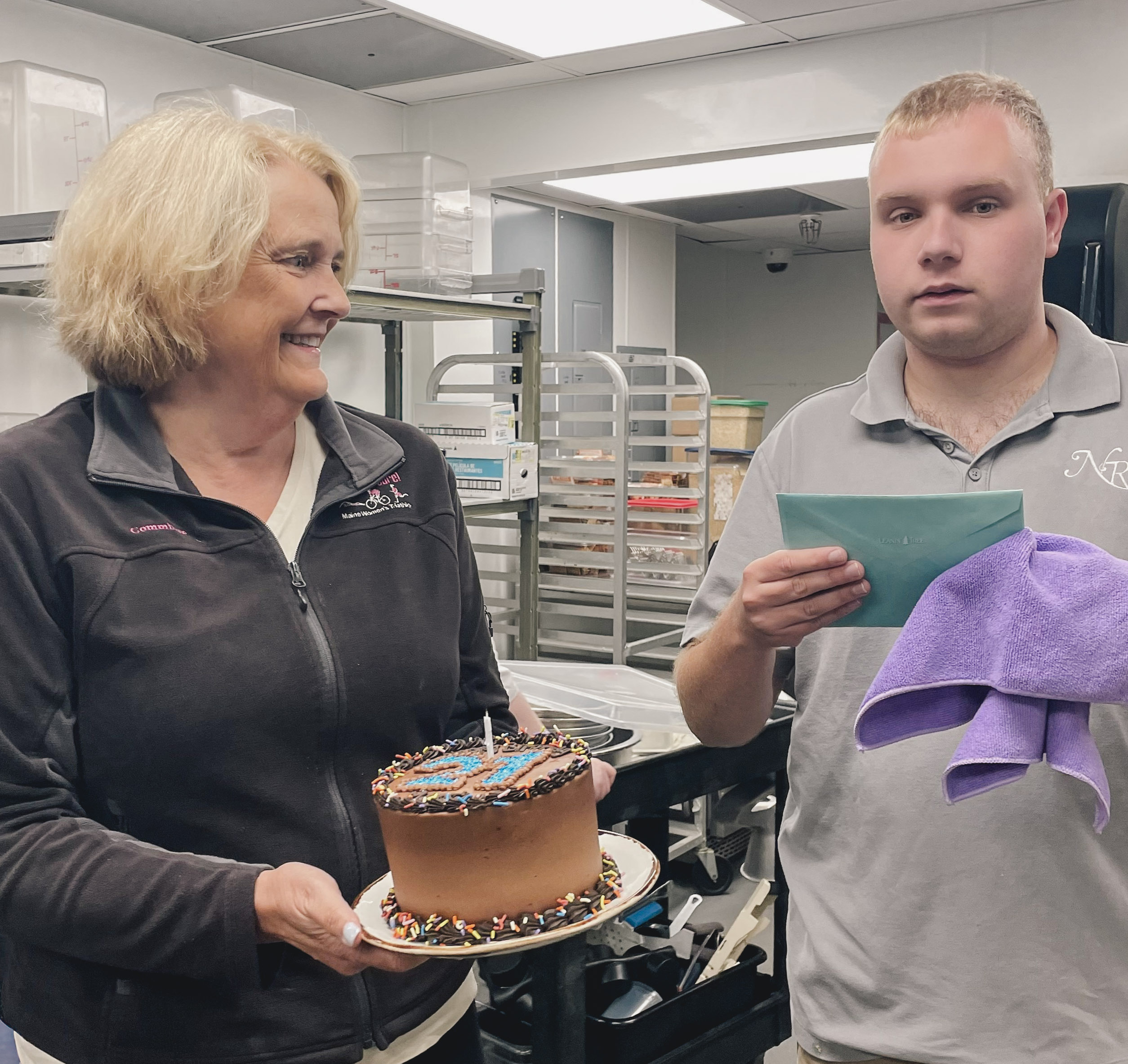 a woman holding a cake and a man holding a towel