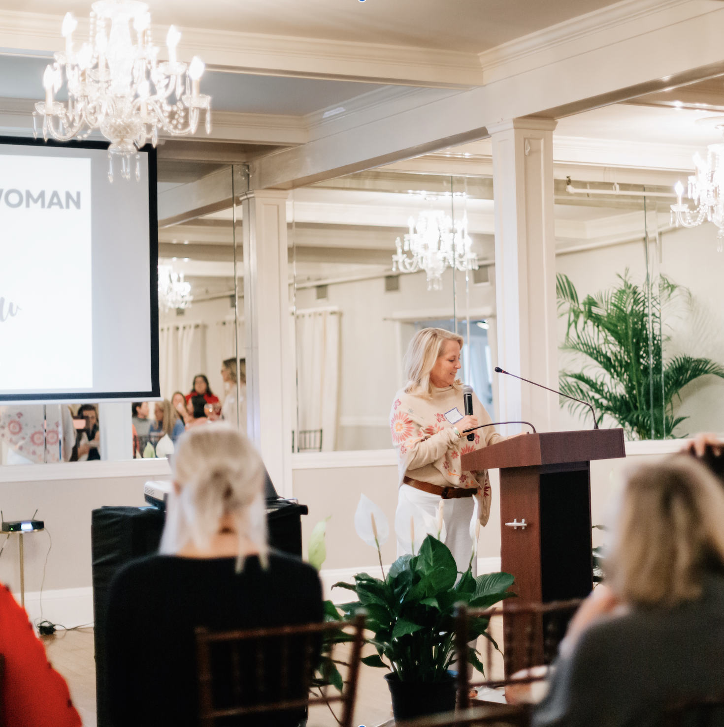 a woman standing at a podium with a microphone