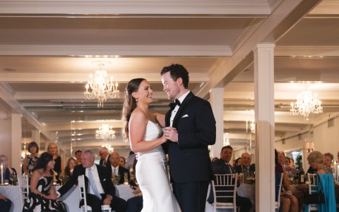 a man and woman dancing in a room with people in the background