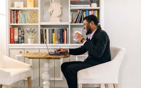 a man sitting at a table with a laptop