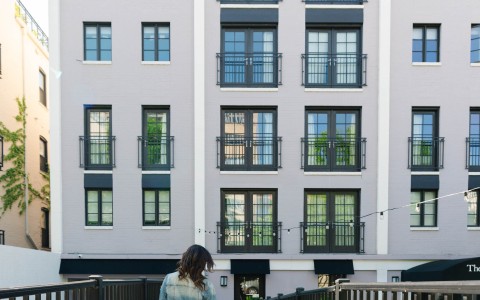 a woman walking a dog on a sidewalk