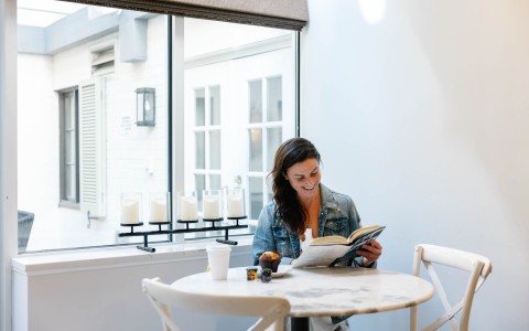 a woman reading a book at a table