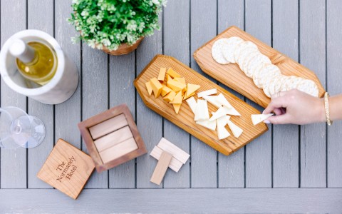 a person holding cheese on a board