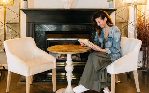 a woman sitting in a chair reading a book