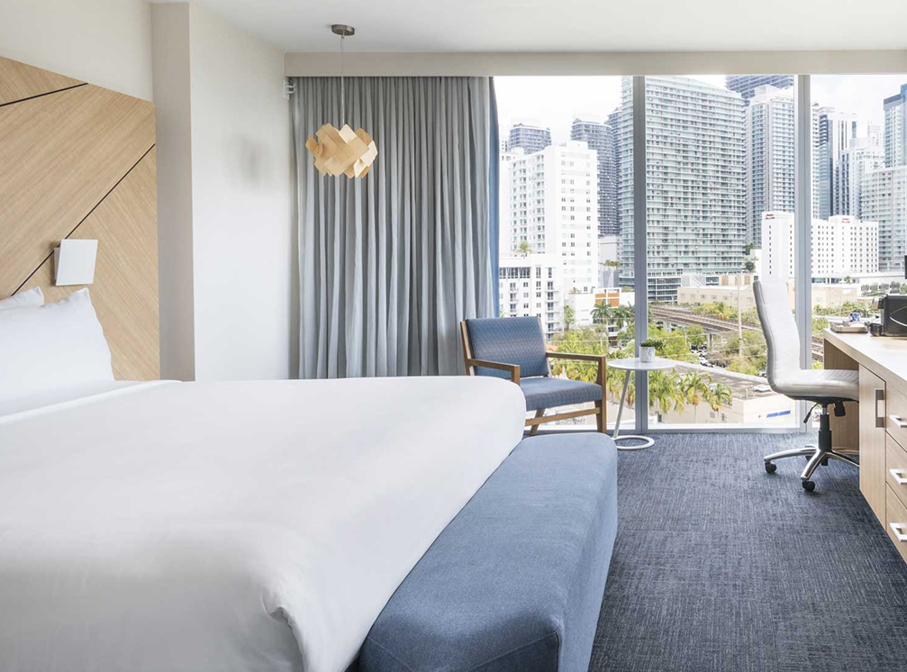 a hotel room with a large window and a bed
