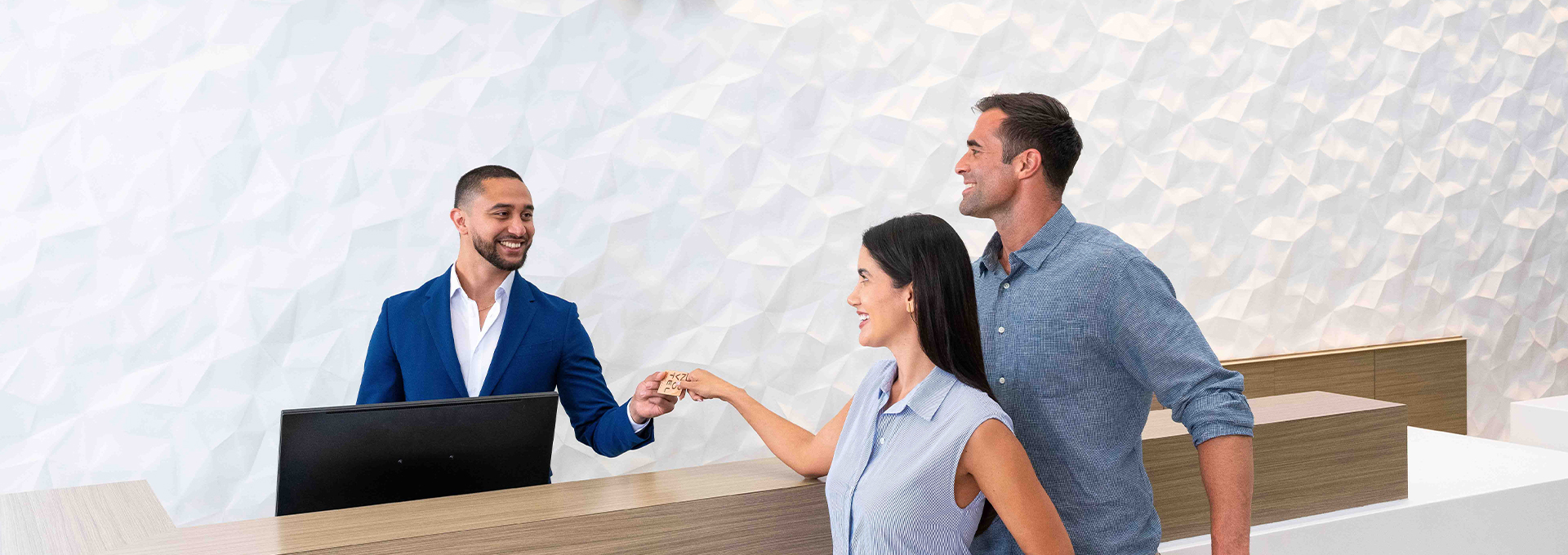 a group of people smiling and holding a small piece of wood