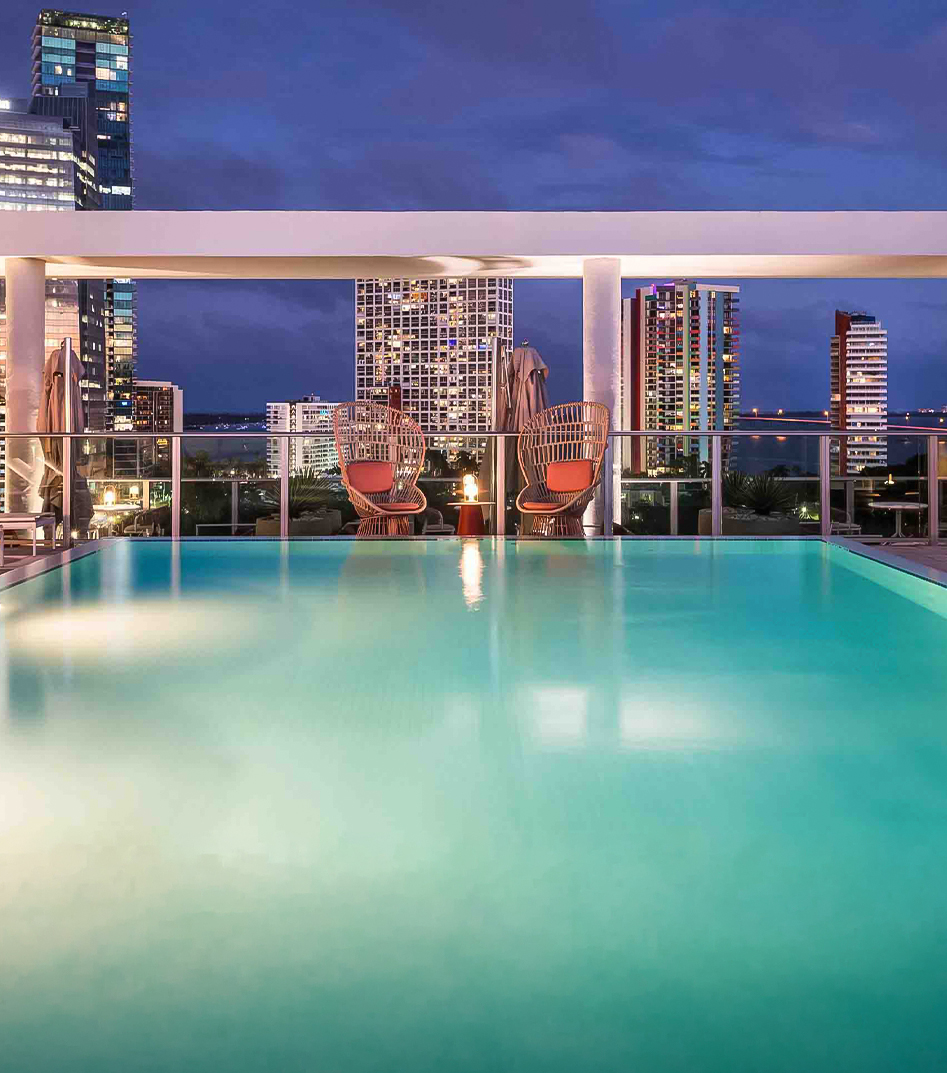 a pool with chairs and a fire in the background