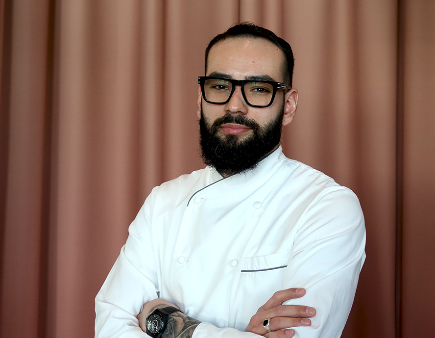 a man with beard wearing a white coat and glasses