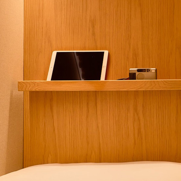 a tablet and camera on a wooden shelf