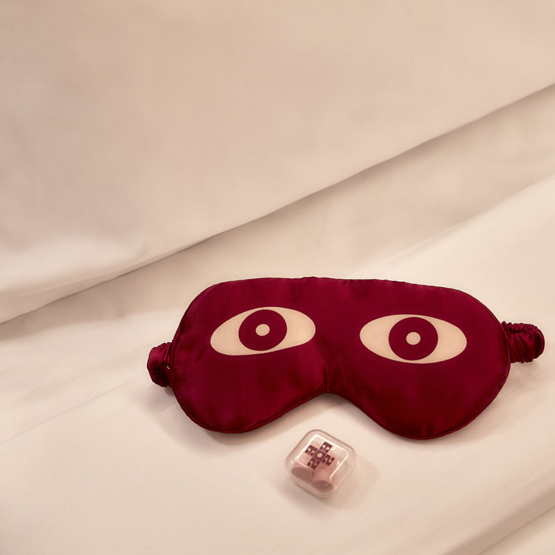 a red eye mask and a plastic container