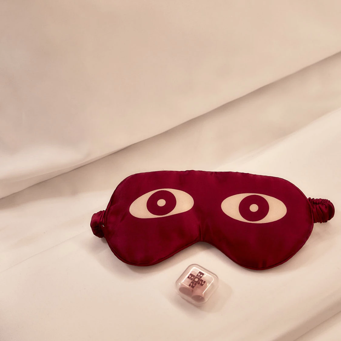 a red eye mask and a plastic container