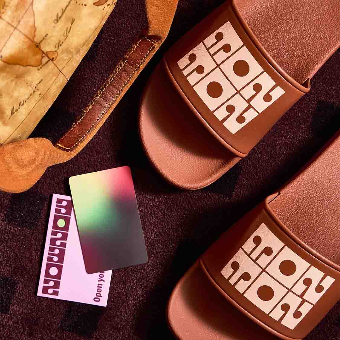 a pair of brown sandals with a map and credit card