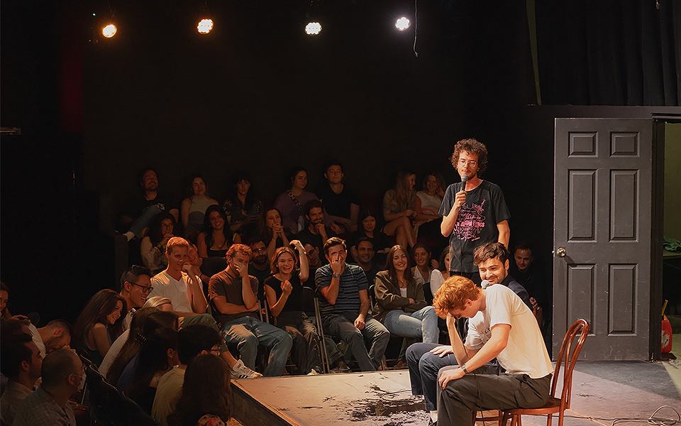 a man standing on a stage with a microphone in front of a crowd