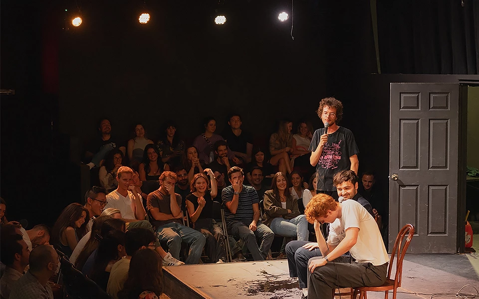 a man standing on a stage with a microphone in front of a crowd
