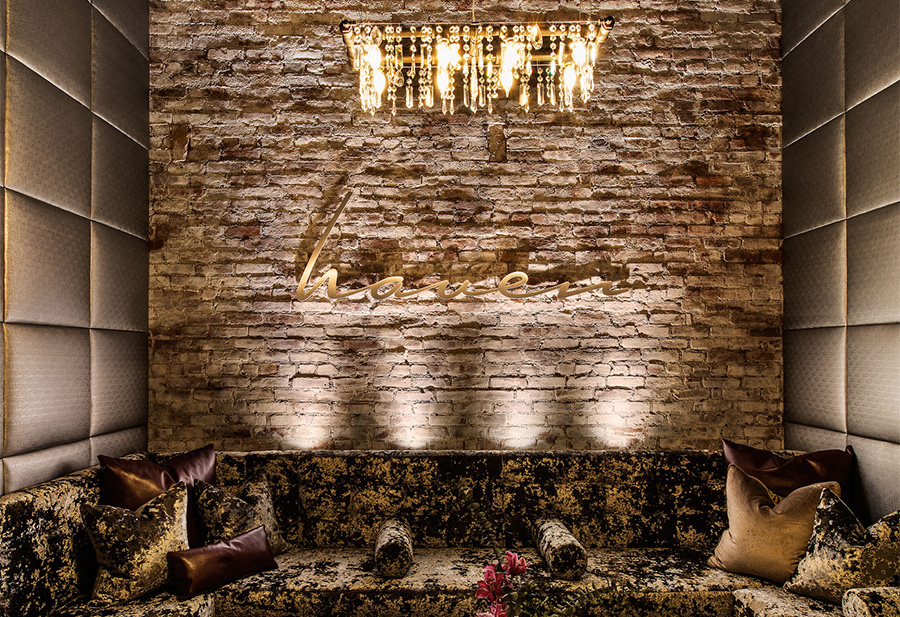 a brick wall with a chandelier and a couch