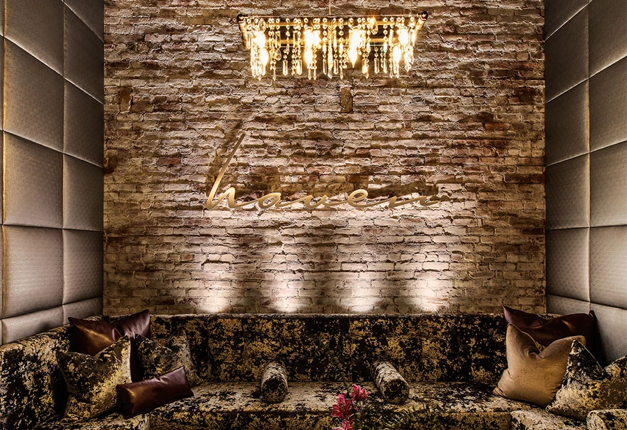 a brick wall with a chandelier and a couch