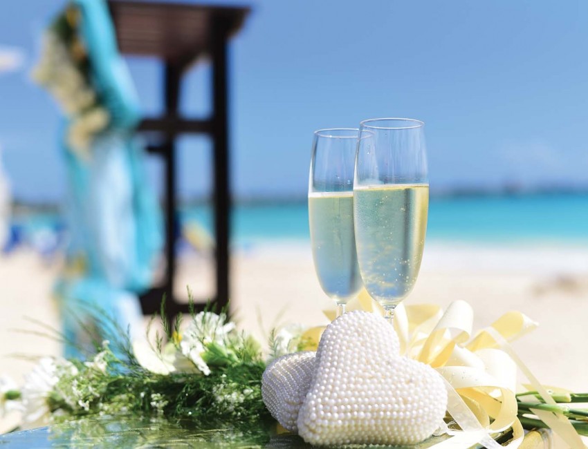two champagne filled glasses with flower bouquet underneath