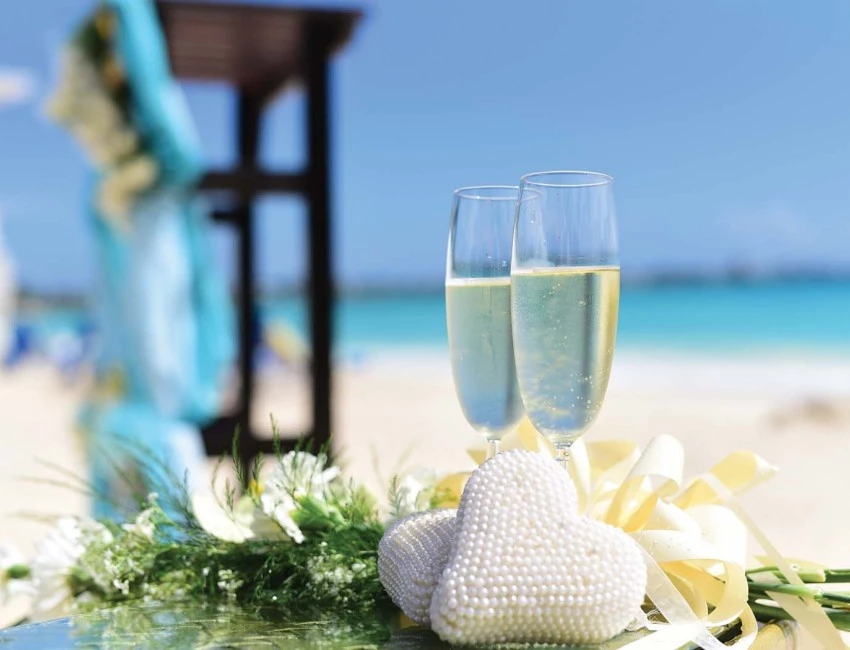 two champagne filled glasses with flower bouquet underneath