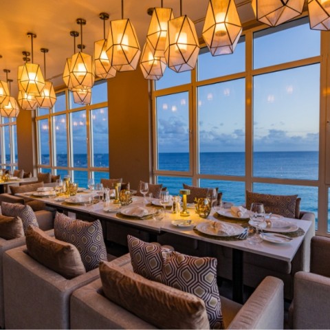 a long table with plates and chairs in a restaurant