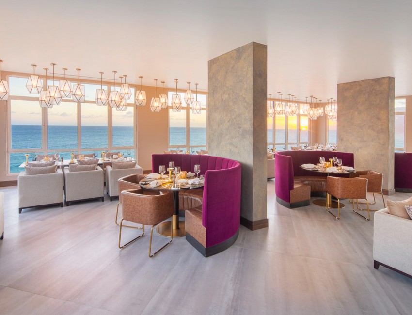 Beautiful dining room with purple booths over looking the ocean 