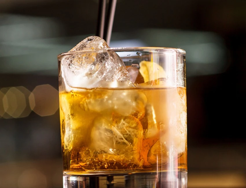 glass of rum with ice cubes filled to the rim