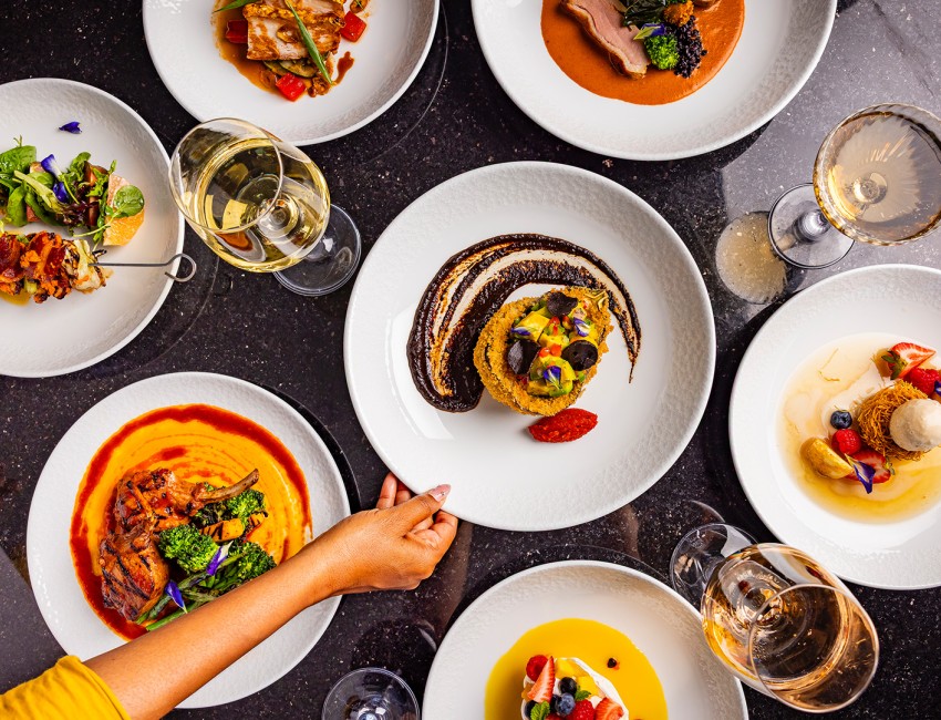 a table with plates of food and glasses of wine