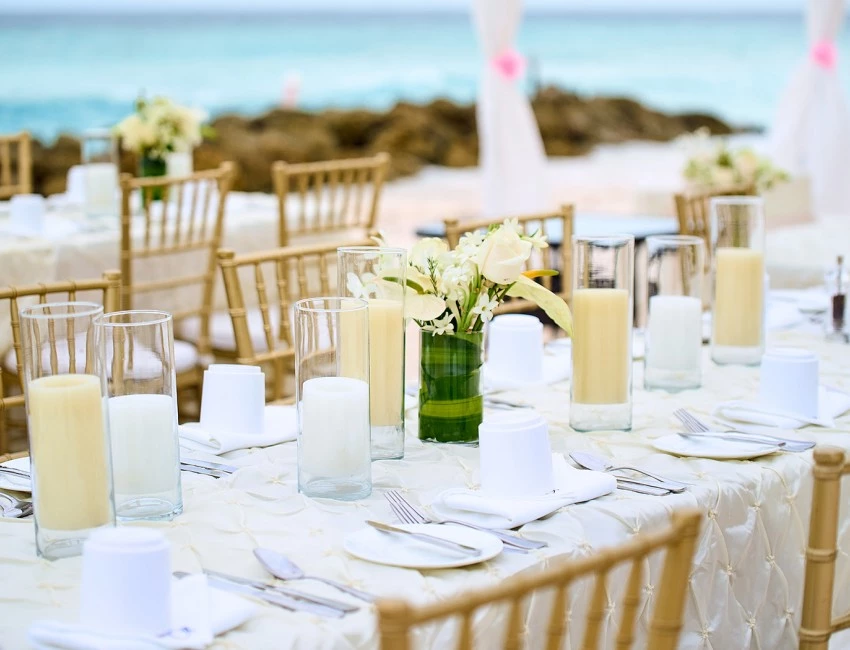 a table set with white tables and white flowers
