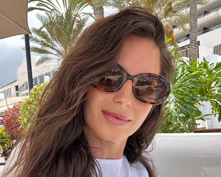 a woman wearing sunglasses and a white shirt