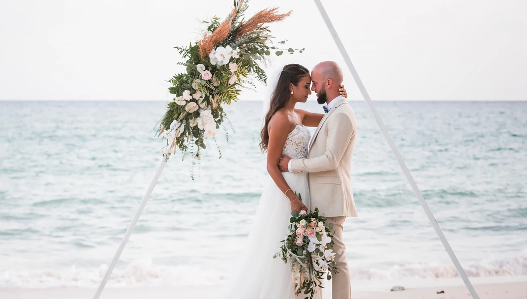 bride and groom hugging under the arbor