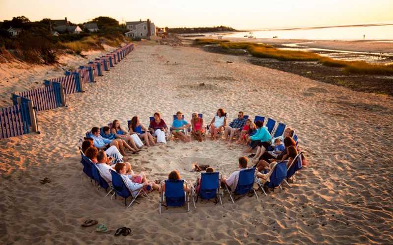 a group of people sitting in chairs on a beach