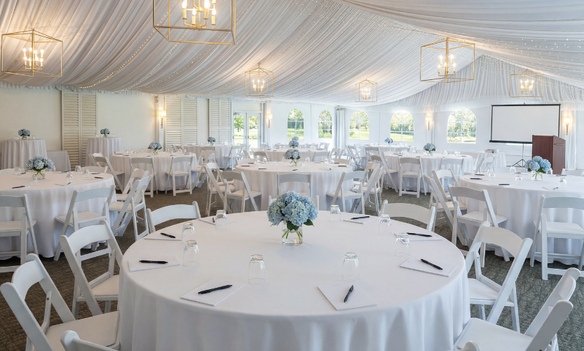 a white tent with tables and chairs