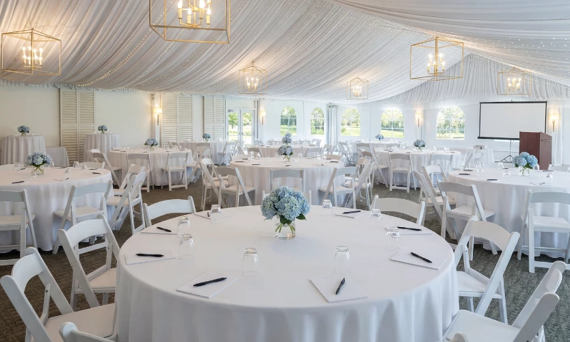 a white tent with tables and chairs
