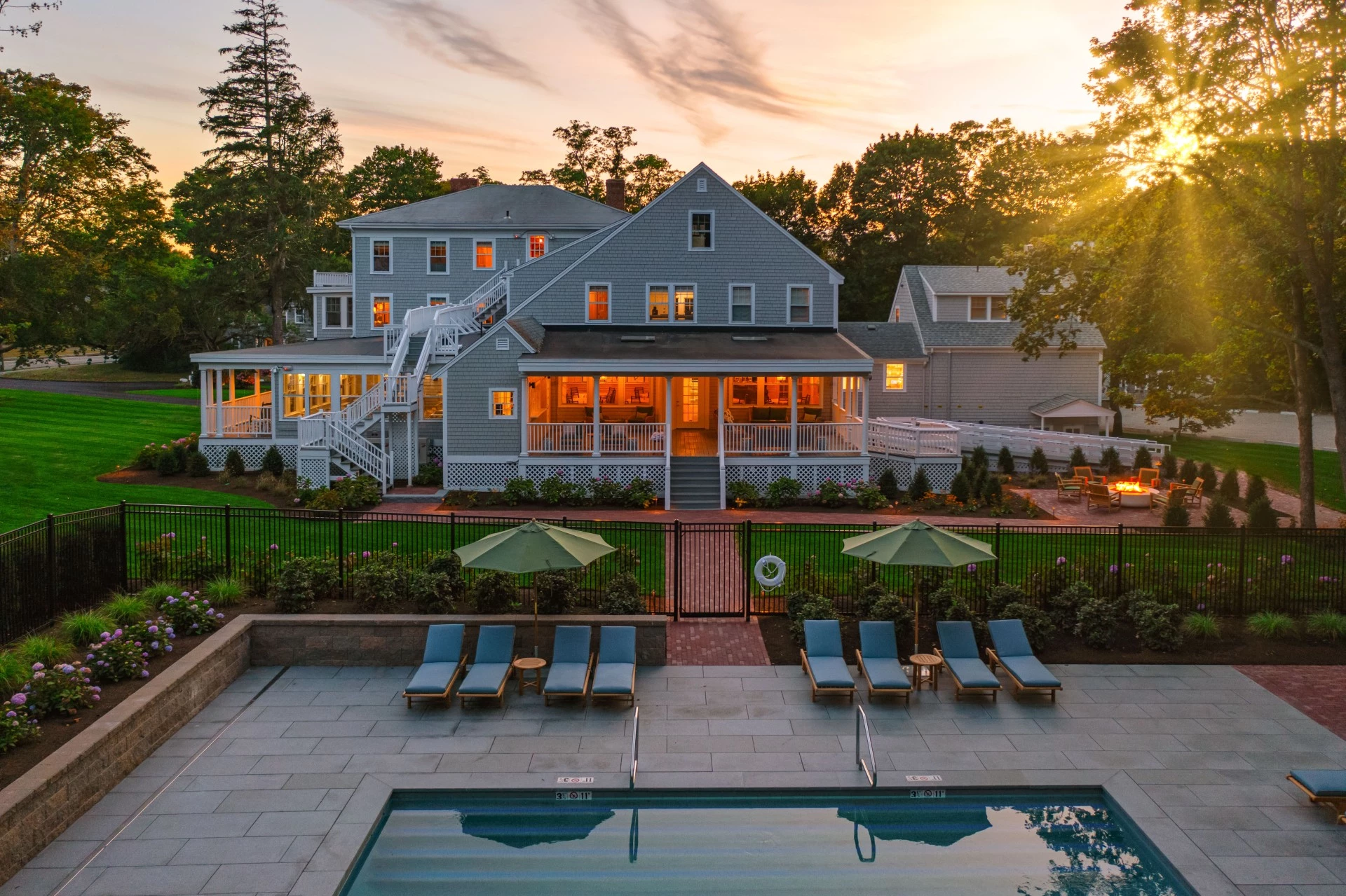 a pool and a house with trees and sun