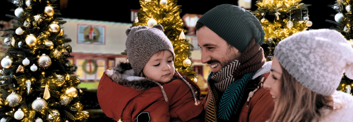 a man holding a baby in a red coat