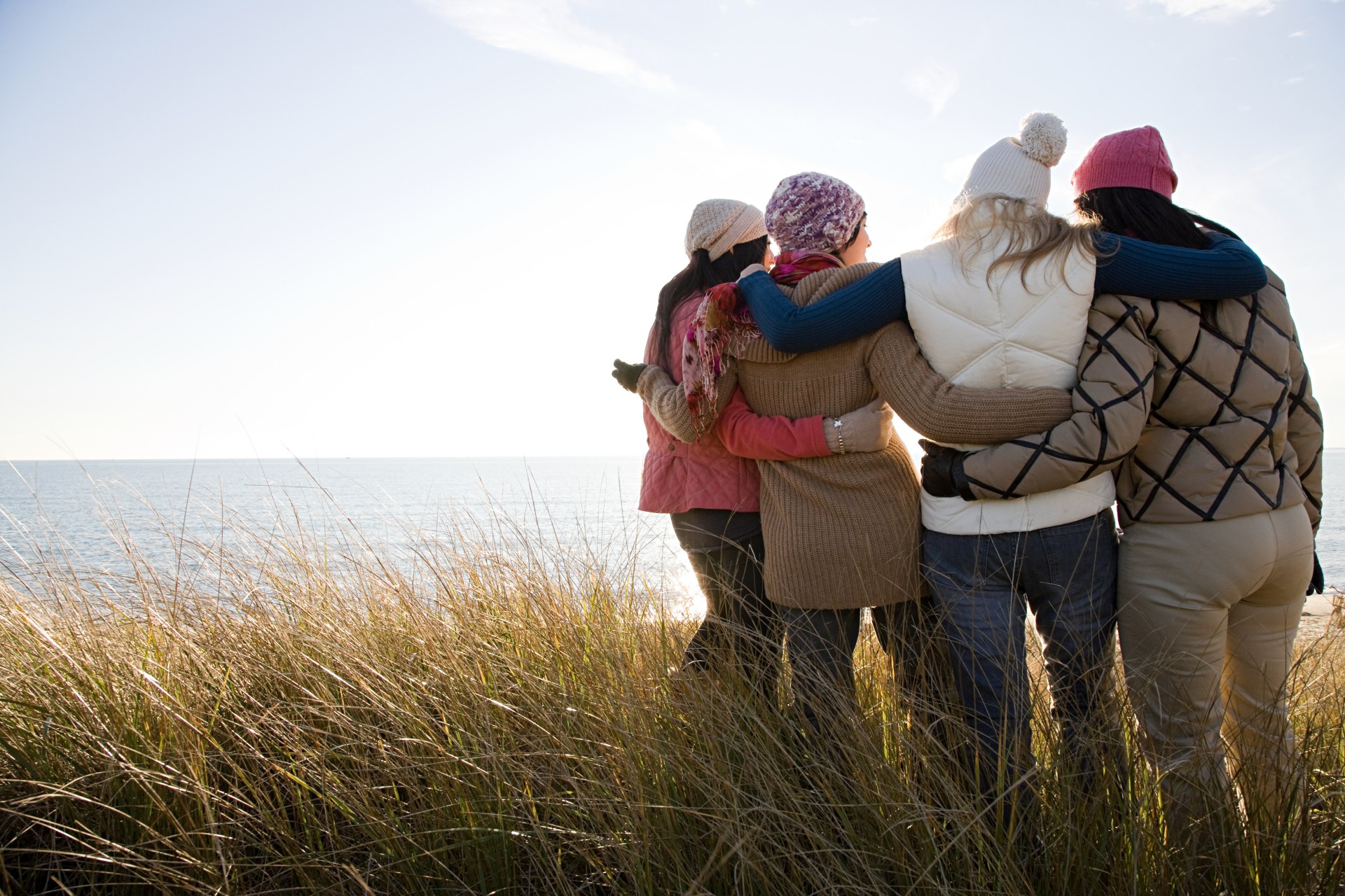 a group of people hugging in a grassy area