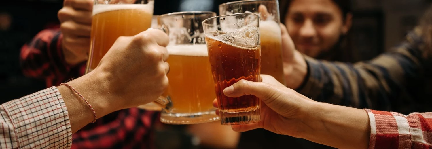a group of people holding glasses of beer