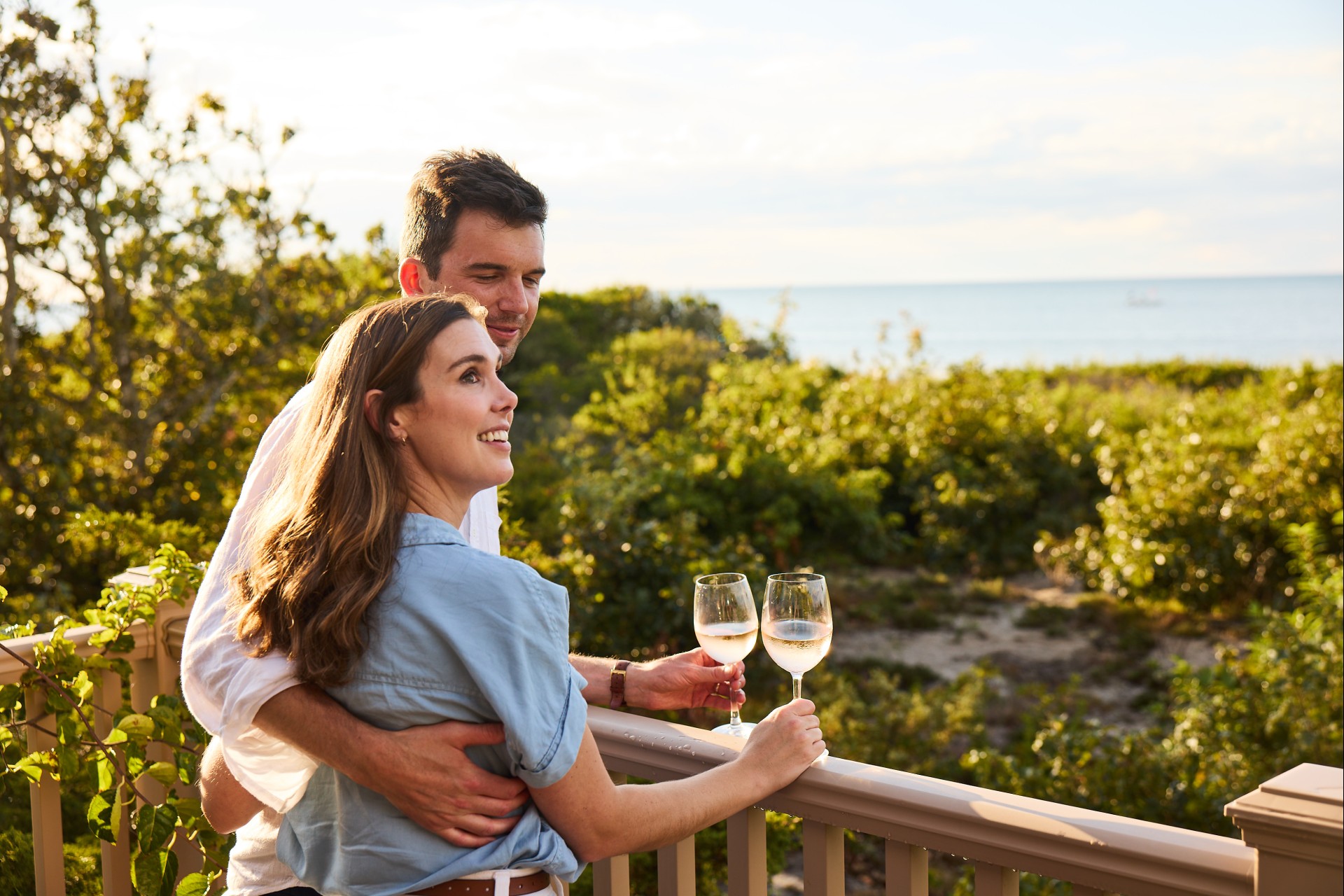 a man and woman holding wine glasses on a bay pines beach villa at Ocean Edge