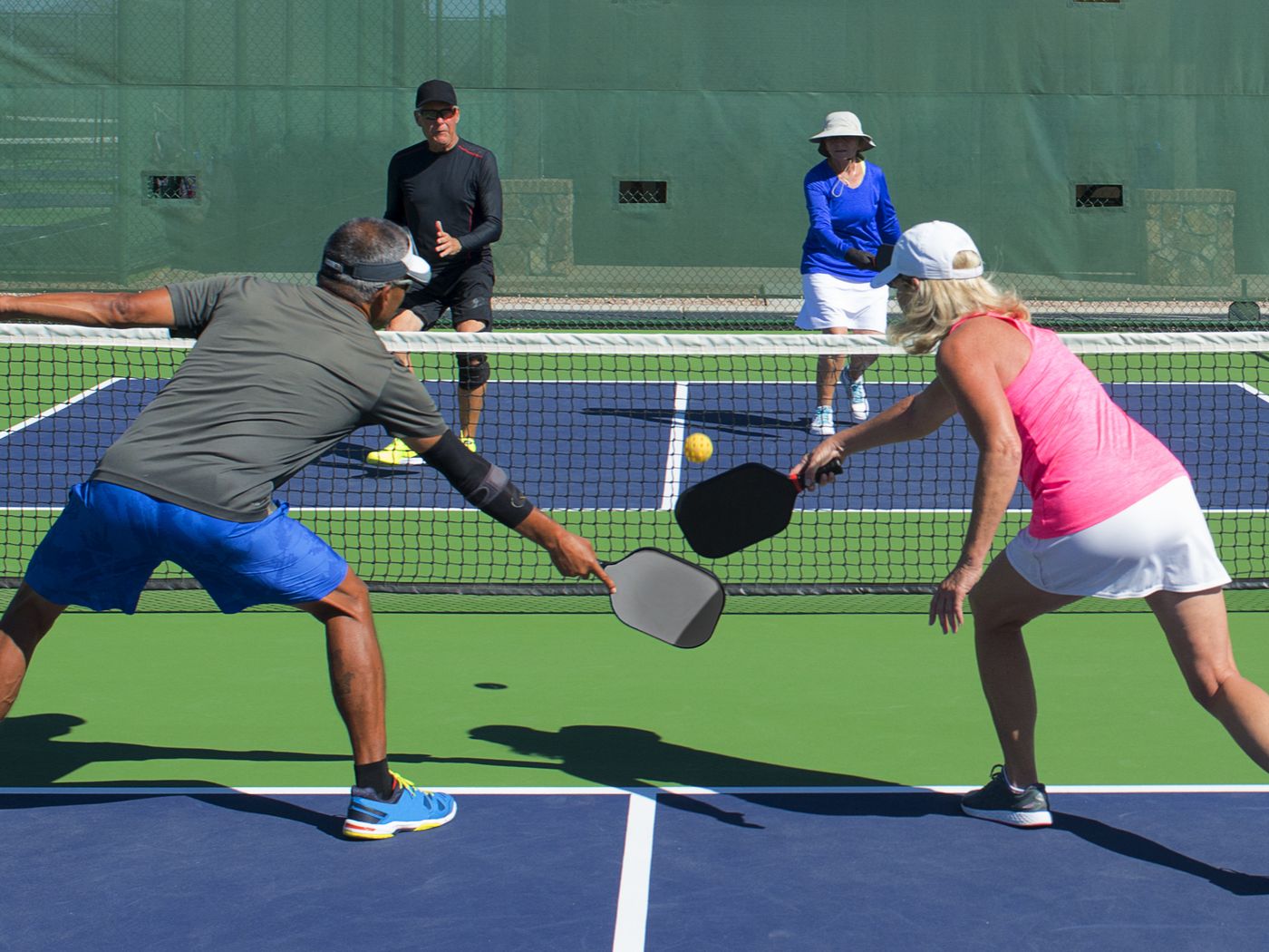 two couples playing a game of pickleball