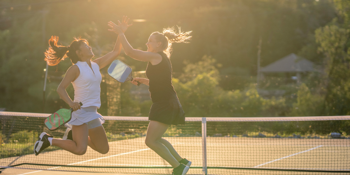 two women playing tennis on a court
