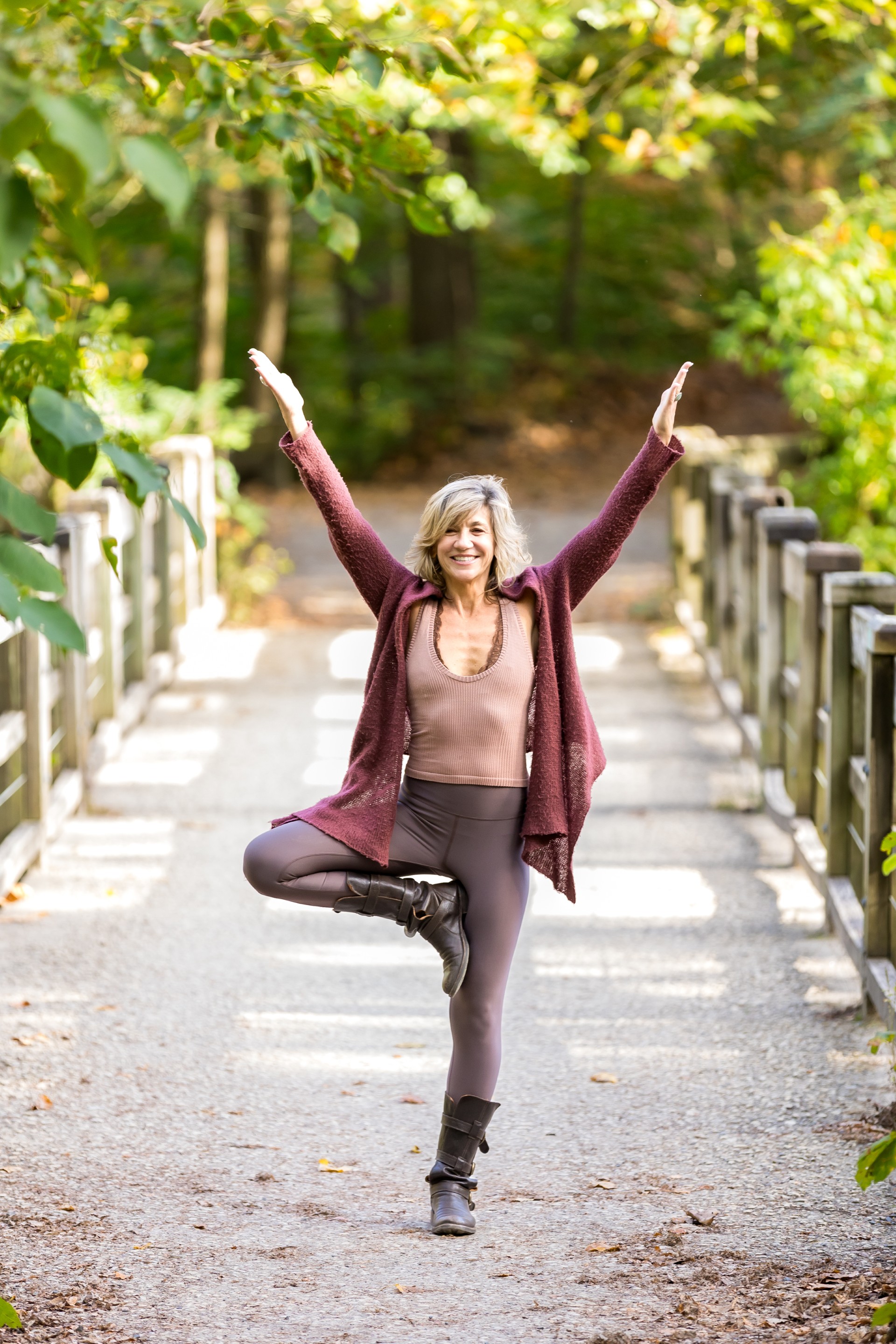 a woman standing on one leg with arms raised