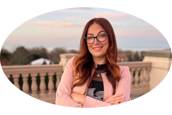 a woman with glasses and a pink jacket